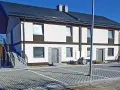 Nowy bliźniak w stanie deweloperskim, gotowy do wykończenia. Nowoczesna elewacja, parking z kostki brukowej.