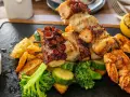 Grillowany ośmiornica i krewetki na szpadzie, podane z pieczonymi ziemniakami, warzywami i cytryną. Pyszne cypr jedzenie.