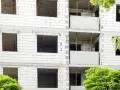 Budowa bloku mieszkalnego, widoczne puste okna i balkony. W przyszłości powstanie tu mieszkanie komunalne.
