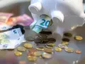 Sparschwein mit Euro-Scheinen und Münzen. Vielleicht reicht es bald für free now taxi preise.
