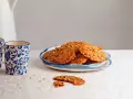Deliciosas galletas de jengibre con trocitos de nuez, servidas en un plato azul y blanco.