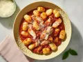 Pyszne gnocchi z kurczakiem w sosie pomidorowym, posypane parmezanem. Idealne danie dla miłośników włoskich smaków.