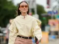 Donna con camicia gialla e pantaloni rosa. Un esempio di pantaloni rosa abbinamenti perfetti per un look casual chic.