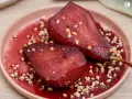 Peras al vino, tiernas y jugosas, bañadas en su propio jugo rojizo y espolvoreadas con trocitos crujientes.