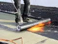 Pose d'une membrane bitumineuse sur une terrasse. Le prix de l'étanchéité d'une terrasse carrelée dépend de la technique utilisée.