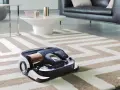 En modern robotdammsugare arbetar på en randig matta i ett stilrent vardagsrum.