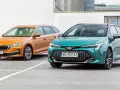 Dwa kombi: pomarańczowa Skoda i zielona Toyota, stojące na parkingu.