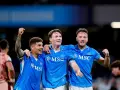 Piłkarze Napoli świętują zwycięstwo nad Hellas Verona. Radość na twarzach zawodników, jeden z nich unosi pięść w geście triumfu.