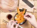 Gotowa tempura jak zrobić? Zobacz, jak pięknie wygląda chrupiąca krewetka w cieście na ryżu, gotowa do podania z sosem.