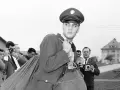 Elvis Presley 1958, in Uniform, wird von Paparazzi umringt, die mit ihren Kameras auf ihn richten.