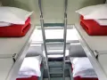 Dwie kuszetki w wagonie PKP z pościelą i drabiną.