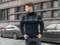 Mężczyzna w czarnym swetrze z warkoczami i wzorem płatków śniegu, idealny na zimowe dni.