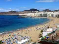 Słoneczna plaża Las Canteras na Gran Canarii, z turystami cieszącymi się ciepłą wodą. Idealna temperatura wody na Gran Canarii zachęca do kąpieli.