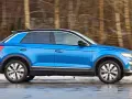 Blauer VW T-Roc fährt durch verschneite Landschaft. Keine Rede von vw t-roc kinderkrankheiten, nur Fahrspaß!