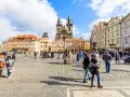 People enjoy Prague tours in Old Town Square, with the Church of Our Lady before Týn dominating the skyline.