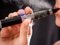 Persona usa un vaper saludable, exhalando vapor blanco.