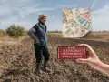 Rolnik na polu, smartfon z napisem "KASA ROLNICZEGO UBEZPIECZENIA SPOŁECZNEGO" i stos banknotów. Emerytura z KRUS.