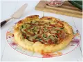Torta salata con zucchine e speck, dorata e invitante, pronta per essere gustata.