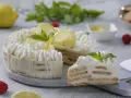 Pastel de limón con crema batida, rodajas de limón y menta.