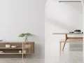 Un espacio minimalista con un aparador de madera y un comedor. Las paredes lisas y el suelo pulido crean un ambiente sereno.