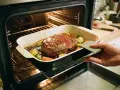Un rosbeef juteux et ses légumes rôtissent dans un plat au four. La cuisson rosbeef est presque terminée, prêt à être dégusté.