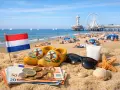 Holenderska flaga, drewniaki, pieniądze i okulary przeciwsłoneczne na plaży. Idealne na wakacje, a może werckpost oferty pracy?