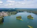 Malownicze jezioro z wyspami i żaglówkami, otoczone lasem i zabudowaniami. To widok, który potwierdza, że to jedne z najpiękniejszych jezior w Polsce.