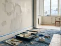Verktyg för att blanda spackel med vatten ligger utspridda på en blå duk. Väggen är förberedd för målning med spacklade fläckar.
