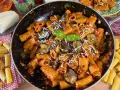 Rigatoni ricchi di melanzane fritte e pomodoro, conditi con ricotta salata grattugiata e basilico fresco. Un piatto di pasta alla norma invitante.