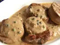 Cuatro medallones de solomillo a la pimienta en una cremosa salsa con granos de pimienta verde.
