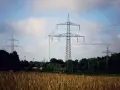 Wiatraki i linie energetyczne na tle nieba. OZE w Polsce to przyszłość, która już dziś zasila nasze domy.