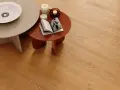 Tavolini e candele su un caldo pavimento in legno chiaro. Valutare il pavimento clap pro e contro per un ambiente accogliente.