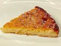 Una fetta di torta di riso, profumata e dorata, come la torta di riso ricetta della nonna, spolverata di zucchero a velo.