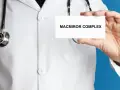 Lekarz w białym kitlu prezentuje kartkę z napisem MACMIROR COMPLEX. Stetoskop wisi na jego szyi.