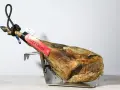 Jamón Joselito en soporte metálico, con etiqueta roja y negra.