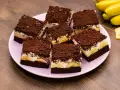 Saftiger Maulwurfkuchen vom Blech mit Bananen und Schokostreuseln auf einem rosa Teller.