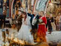 Para młoda podczas ceremonii ślubu prawosławnego. Pan młody w mundurze, panna młoda w bieli. Nad nimi trzymane są korony.