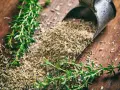 Frischer und getrockneter Thymian liegen auf Holz. Die **Thymian Wirkung Haut** ist bekannt für ihre entzündungshemmenden Eigenschaften.