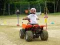 Chłopiec w kasku na quadzie uczy się zasad ruchu drogowego. To świetna kategoria pojazdów, czym można jeździć na specjalnych torach.