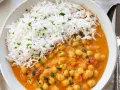 Un delicioso curry de garbanzos con arroz blanco esponjoso, espolvoreado con perejil fresco.
