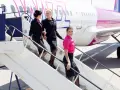 Uśmiechnięte stewardessy Wizz Air schodzą po schodkach. Ciekawe, ile zarabia stewardessa Wizz Air za taką pracę?