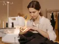 Une couturière utilise une surjeteuse pour créer un patron housse de chaise Burda.