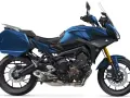 Niebieski motocykl Yamaha Tracer 900 GT z kuframi, gotowy na dalekie podróże.