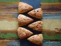 Sechs dreieckige Schokoladen-Scones liegen auf einem rustikalen Holztisch. Perfekt für alle, die keine komplizierten discard rezepte mögen.