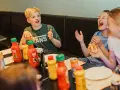 Barn skrattar och äter korv med bröd vid ett bord med Felix ketchup och senap. Perfekt för tips på femkamp!