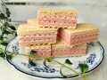 Piękne wafle z mlekiem w proszku, ułożone na talerzyku z niebieskimi wzorami, ozdobione zielonymi listkami.