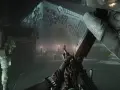 Gracz z karabinem w rękach, gotowy do akcji w grze Escape from Tarkov na PS5. W tle budynek TerraGroup i ciężarówka.