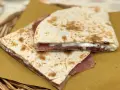 Piadine ripiene di prosciutto e formaggio, pronte per essere gustate dopo la cottura.