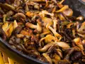 Deliciosas setas al ajillo en sartén, doradas y jugosas, listas para disfrutar.
