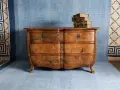 Cómoda de madera antigua, lista para pintar. Unos libros viejos descansan sobre ella.